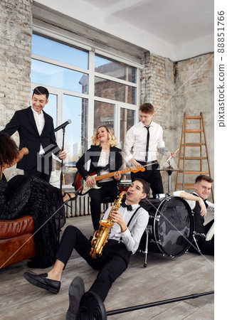 Young international musicians, a band performing on the loft stage. The concept of music, hobby, festival. Inspiration creativity. Young international musicians, a band performing on the loft stage. The concept of music, hobby, festival. Inspiration creativity. 88851766