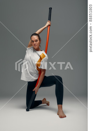 beautiful girl in sports uniform is training kung fu in the studio, fighter athlete, practicing martial arts with a stick 88851803