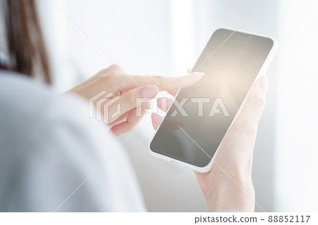 Woman holding a smartphone 88852117