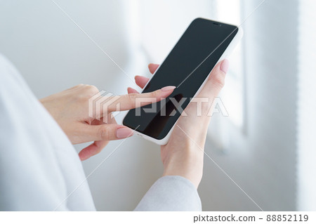 Woman holding a smartphone 88852119