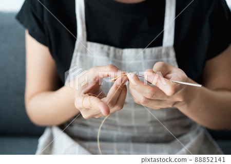 Happy Asian young woman enjoy knitting a cloth and knitwear at home in a living room, leisure activity and hobby in free time. Handcraft cotton crochet. Asian cheerful girl knitting a crochet yarn. Happy Asian young woman enjoy knitting a cloth and knitwear at home in a living room, leisure activity and hobby in free time. Handcraft cotton crochet. Asian cheerful girl knitting a crochet yarn. 88852141