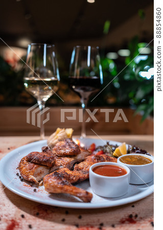 Georgian cuisine dish roasted chicken tapaka on plate and wine in restaurant 88854860