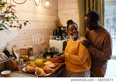 Happy young black woman looking at her husband standing behind 88855673