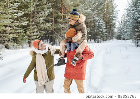 Young contemporary family of father, mother and son enjoying winter day in park Young contemporary family of father, mother and son enjoying winter day in park 88855765