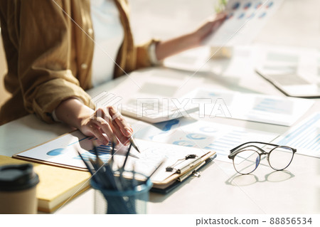 Close up Business woman hand using calculator to calculate the company's financial results and budget. Account Audit Concept. Close up Business woman hand using calculator to calculate the company's financial results and budget. Account Audit Concept. 88856534
