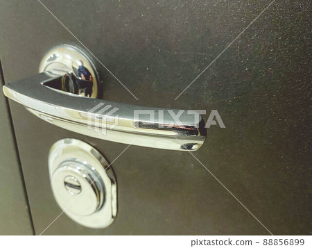 brown, metal front door. keyhole on the door. The handle is made of silver metal. porch in a multi-storey building brown, metal front door. keyhole on the door. The handle is made of silver metal. porch in a multi-storey building 88856899
