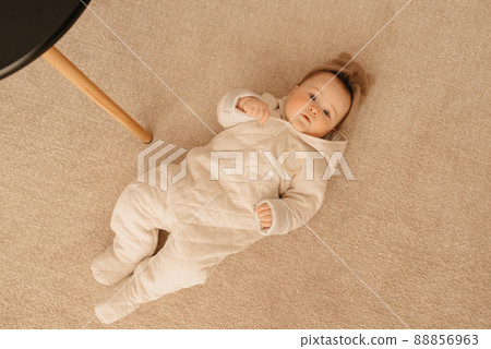 Seven month girl is lying on the carpet Seven month girl is lying on the carpet 88856963