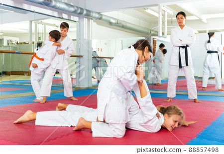 Teenager girls practicing karate in pairs 88857498