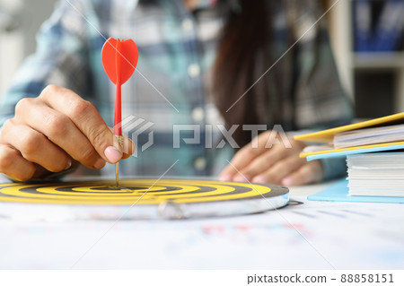 Person holds dart in center of playing darts closeup Person holds dart in center of playing darts closeup 88858151