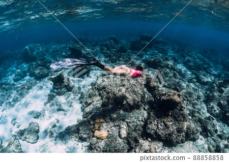 Woman with fins dive to corals, snorkeling in tropical transparent ocean. 88858858