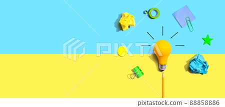 Brainstorming concept with a light bulb and school supplies - Flat lay 88858886