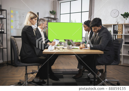 Diverse group of successful multiracial focused businesspeople in the conference room Diverse group of successful multiracial focused businesspeople in the conference room 88859135