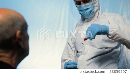 Doctor is making the swab test on the noise of the patient with covid suit 88859397
