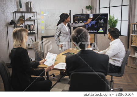 Beautiful motivated smart african american businesswoman demonstrating infographics on digital board Beautiful motivated smart african american businesswoman demonstrating infographics on digital board 88860104