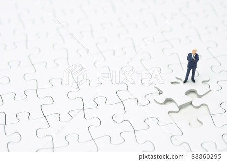 A businessman folding his arms on a jigsaw puzzle A businessman folding his arms on a jigsaw puzzle 88860295