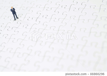 A businessman folding his arms on a jigsaw puzzle A businessman folding his arms on a jigsaw puzzle 88860296