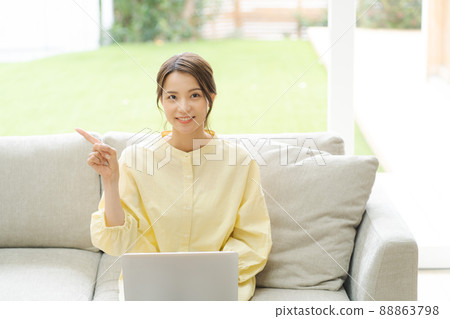 一個操作個人電腦的女人,家裡的沙發 一個操作個人電腦的女人,家裡的沙發 88863798
