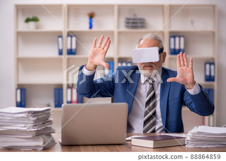 Aged male employee wearing virtual glasses in the office 88864859