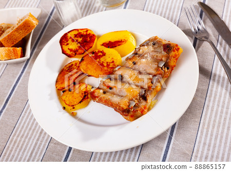Appetizing baked pork ribs with fried sliced potatoes Appetizing baked pork ribs with fried sliced potatoes 88865157