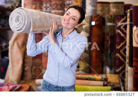Woman holding carpet before buying to her house Woman holding carpet before buying to her house 88865327