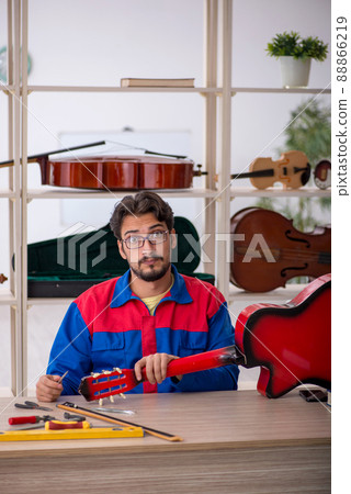 Young man repairing musical instruments at workshop 88866219