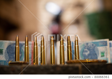 A view from a distance of live ammunition and files of paper cash. 88866361