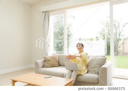 A woman who operates a personal computer, a sofa at home 88866373