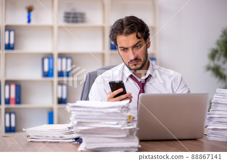 Young male employee and too much work in the office 88867141
