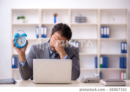 Young male employee in time management concept Young male employee in time management concept 88867162