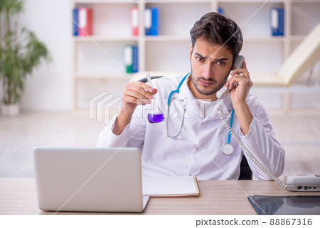 Young male doctor working in the clinic Young male doctor working in the clinic 88867316