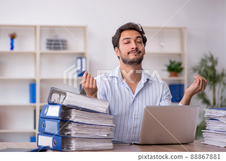 Young male employee unhappy with excessive work in the office Young male employee unhappy with excessive work in the office 88867881