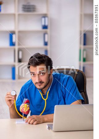 Young male doctor cardiologist working in the clinic Young male doctor cardiologist working in the clinic 88867891