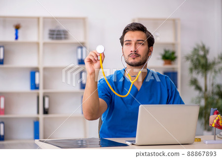 Young male doctor working in the clinic Young male doctor working in the clinic 88867893
