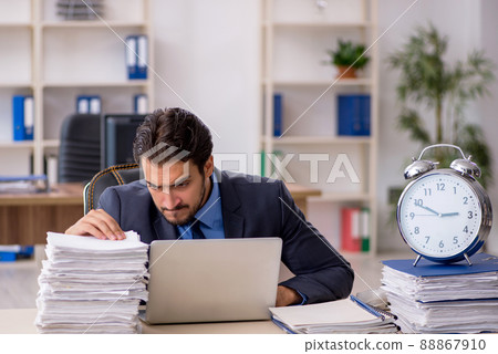 Young male employee in time management concept Young male employee in time management concept 88867910