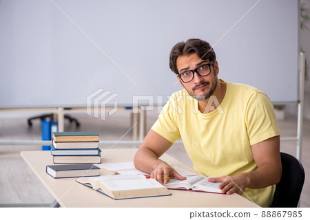 Young male student preparing for exams in the classroom Young male student preparing for exams in the classroom 88867985