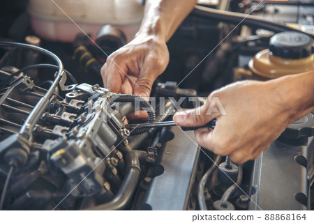 Close up Car Mechanic man hands repairing car auto repair shop. Man hands fixing machinery vehicle mechanical service. open vehicle hood checking up auto mobile. Vehicle Car maintenance engineer. 88868164
