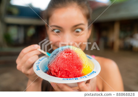 Hawaiian shave ice happy woman tourist making funny face hungry eating sweet frozen snow cone local dessert food of Hawaii 88868828