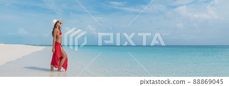 Luxury beach vacation elegant tourist woman walking relaxing in beachwear hat on white sand Caribbean beach. Lady tourist on holiday vacation resort. Banner panorama landscape Luxury beach vacation elegant tourist woman walking relaxing in beachwear hat on white sand Caribbean beach. Lady tourist on holiday vacation resort. Banner panorama landscape 88869045