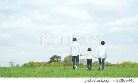 Parent-child family walking in the meadow holding hands Child-rearing natural environment 88869443