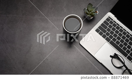 Top view laptop computer, coffee cup and eyeglasses on dark stone background. Copy space for your information content. 88871469