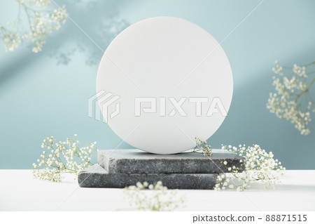 Cylinder podium with white flowers, geometric shadows. Scene to show products. Showcase, display case. 88871515