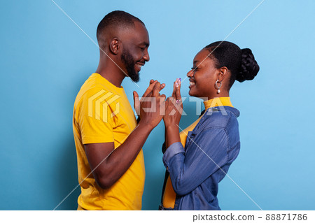 People keeping fingers crossed to wish for good luck and fortune in front of camera. Positive girlfriend and boyfriend hoping for miracle, feeling excited about future. Superstitious lovers 88871786