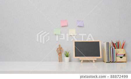 Empty chalkboard, potted plant and stationery on white table. Copy space for your information content. Empty chalkboard, potted plant and stationery on white table. Copy space for your information content. 88872499