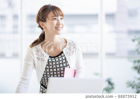 Business woman standing in front of a laptop in the office 88873912