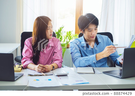 negotiation, analysis, discussion,asian male economist pointing out a document explaining the investment finance program to the company owner to plan marketing and hedging business risks 88874429