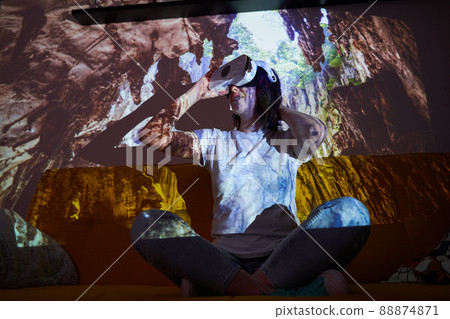 Woman uses virtual reality glasses to go to another point of light and see cave. Woman uses virtual reality glasses to go to another point of light and see cave. 88874871