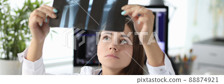 Woman doctor looking at xray of hand in clinic office 88874921