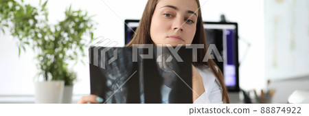 Doctor carefully examining xray of patient hand in clinic Doctor carefully examining xray of patient hand in clinic 88874922