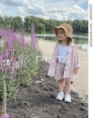 Baby girl in pin clothes and a straw hat 88876055