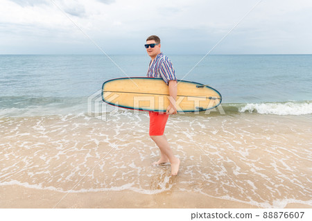 Portrait of young adult stylish caucasian man wear casual shirt and sunglasses enjoy having leisure time surfing at ocean seaside travel vacation tropical resort. Male surfer person surfboard coast Portrait of young adult stylish caucasian man wear casual shirt and sunglasses enjoy having leisure time surfing at ocean seaside travel vacation tropical resort. Male surfer person surfboard coast 88876607